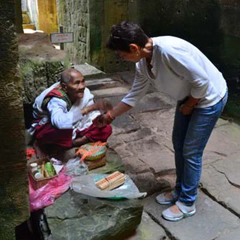 Elderly monk working at a temple ruin. Rural Thailand.